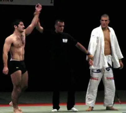 The referee raises David Avellan’s arm as the winner over Rener Gracie, who stands to the side in a white gi, at the Ultimate Submission Showdown